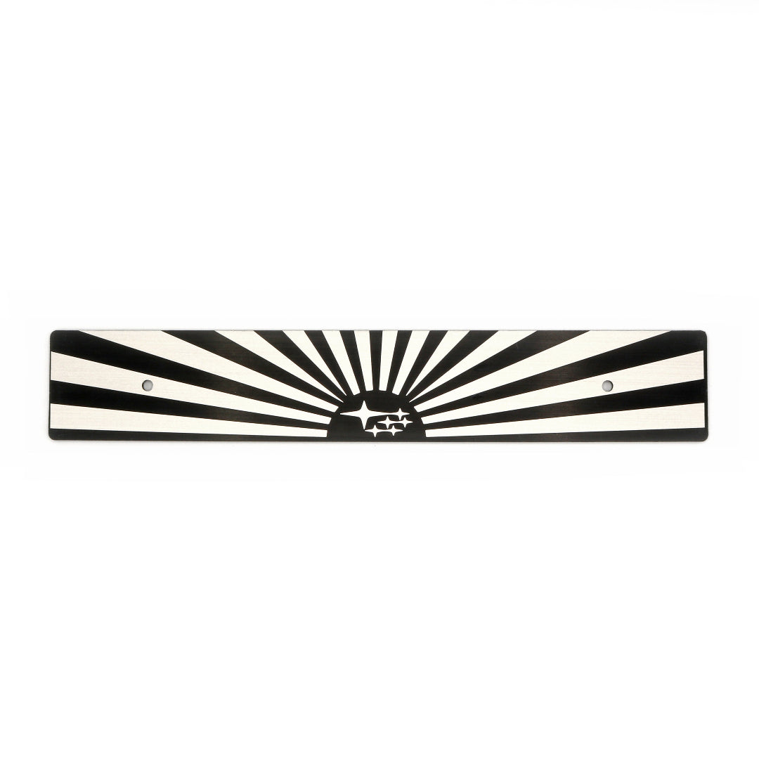 A black and white sun and subaru starburst-patterned license plate delete with mounting holes.