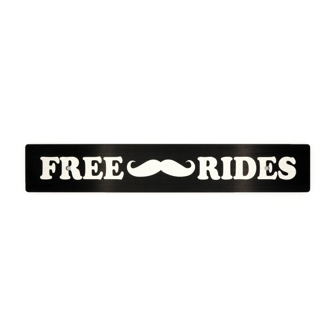 A black anodized aluminum license plate delete with white text and a mustache symbol, reading 'FREE Mustache Rides'.