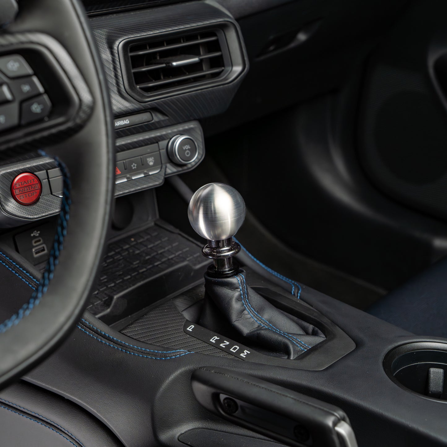 Close-up of a car's gear shift lever and surrounding interior.