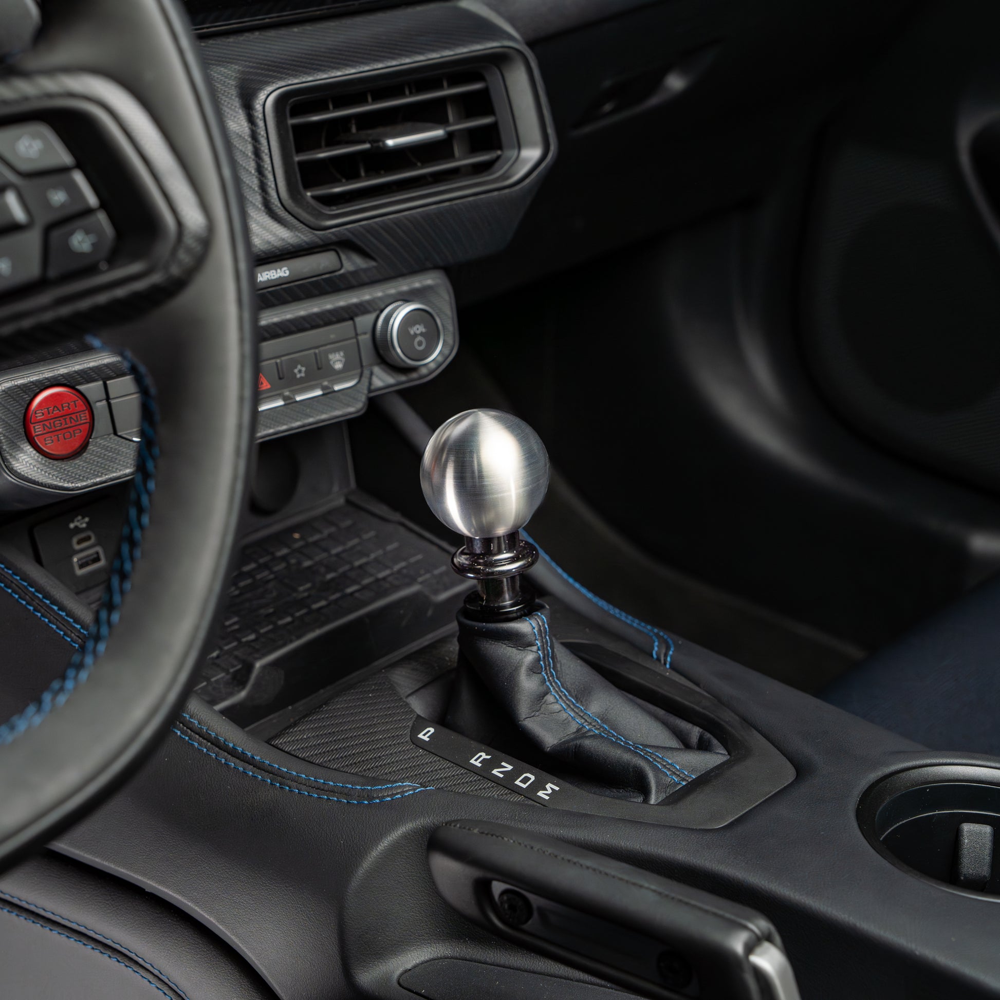 Close-up of a car's gear shift lever and surrounding interior.