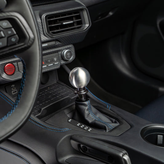Close-up of a car's gear shift lever and surrounding interior.
