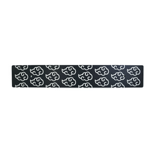 A black anodized aluminum license plate delete with white cloud patterns