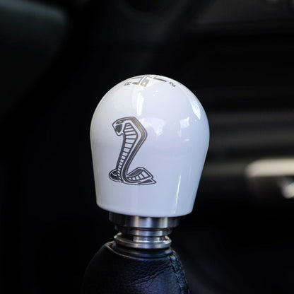 Car gear shift knob with Shelby logo on a dark background