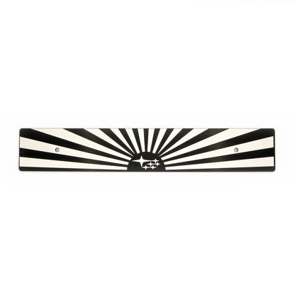 A black and white sun and subaru starburst-patterned license plate delete with mounting holes.