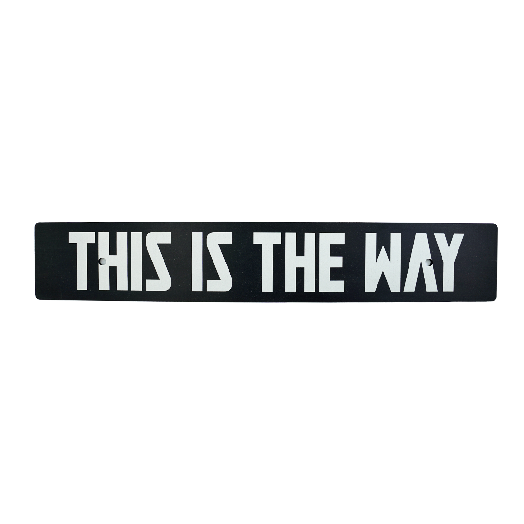 A black anodized aluminum license plate delete with white text 'THIS IS THE WAY' on it.